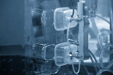 Close up scene material handling process the food container by robotic system from injection machine.