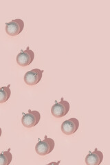 Silver Christmas baubles arranged diagonally on pink