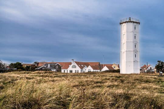 White Lighthouse Over Coastal Village With Grassy Field, Houses, and Wide Blue Sky, Skagen, Denmark