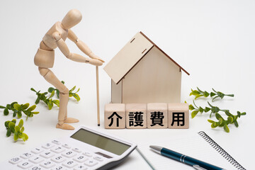 老人のデッサン人形と介護費用のイメージ