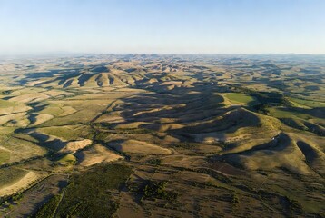 Undulating dry hills and green fields in an expansive landscape