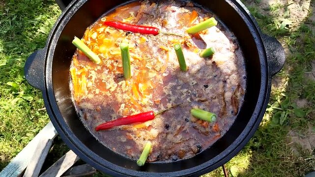 Pilaf recipe outdoors in a cast iron cauldron bubbling zirvak rice and carrots top view camera moves up clip for food blogs how to videos and spice brands