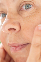 Obraz premium Close up female face hands on cheeks skin care routine, natural beauty concept personal wellness relaxation, healthy lifestyle, facial massage detail, Daily skincare ritual, Gentle touch femininity