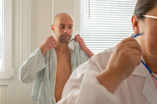 bald male patient in hospital, man in standard issue hospital gown, expression anxiety and worry before surgery or a critical diagnosis, patient portrait man, contemplation and reflection