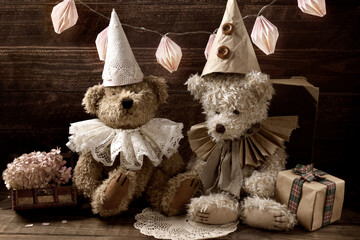 Two vintage style teddy bears in ruff collars and caps celebrating birthday in sepia color
