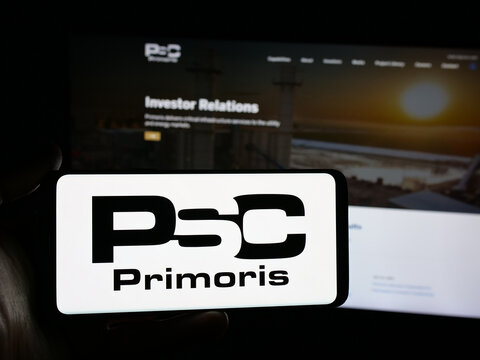 Stuttgart, Germany - 11-20-2025: Person holding smartphone with logo of company Primoris Services Corporation (PSC) on screen in front of website. Focus on phone display.