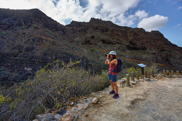 Fototapeta premium Woman photographer at canyon viewpoint