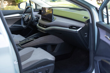 Inside car interior with front leather seats, steering wheel, windows, console, gear shift, electric buttons, digital speedometer. Luxury car interior. Car detailing series. Prestige modern car