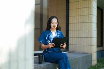 Nurse holding digital tablet sitting on break