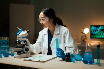 Female scientist performing medical research in a dark laboratory