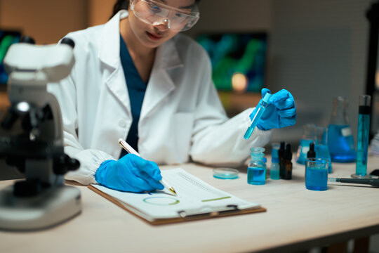 Female scientist conducting research, analyzing data in laboratory