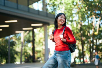 Young Asian student walking happy on college campus