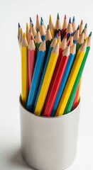 Assorted colored pencils in a metal container on a white surface in a close up studio shot image view