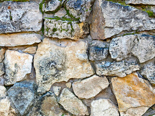 Close-up view of a weathered stone wall showcasing natural textures and colors for design inspiration and background use
