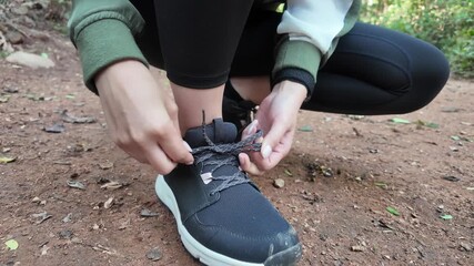 Close up - Running shoes runner woman tying laces sneakers for summer run in the city. Jogging girl exercise motivation health and fitness exercise, lifestyle.