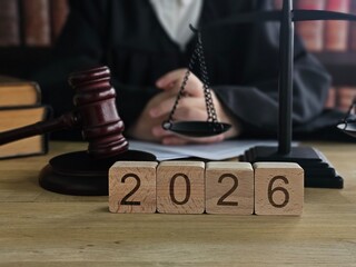 Judge at a courtroom with gavel and scales of justice, looking ahead towards the year 2026 during a legal proceeding concept