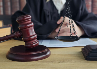 Judge presiding over courtroom with gavel, scales of justice, and legal documents on the table concept