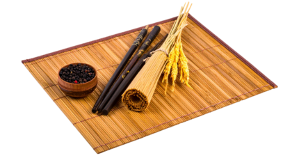 Asian-themed still life chopsticks, bamboo mat, wheat bundle, peppercorns, and rolled mat
