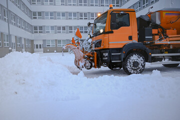 Snowplow clearing a path of fresh snow in an urban area during winter