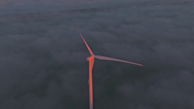 Offshore wind farm at the Afsluitdijk glowing at sunrise, producing green energy.