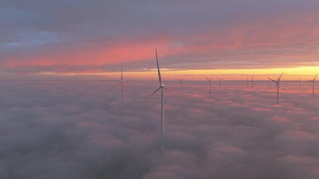Windmills offshore at the Afsluitdijk generating sustainable energy at sunrise.