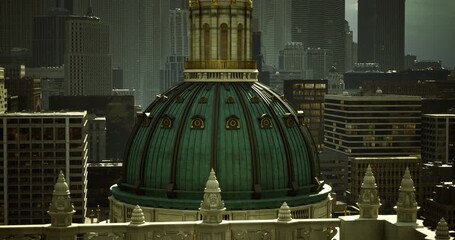 The ornate dome atop a historic building stands out against a backdrop of modern skyscrapers, reflecting the bright sunlight on a clear day, showcasing the citys architectural contrast.