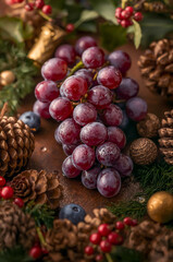 Fresh Red Grapes Cluster with Christmas Pinecones and Holiday Decorations