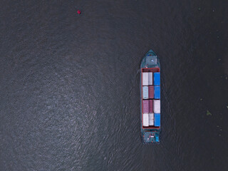 Large ship is floating in the water. The ship is blue and red