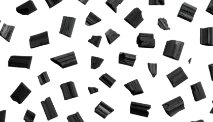 Black background with scattered charcoal pieces of varying sizes and shapes, creating a pattern