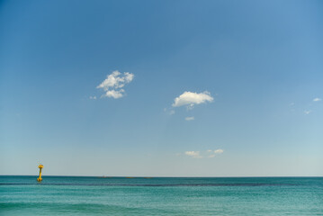 The sky is blue and clear. There are no clouds in the sky. The ocean is calm and blue