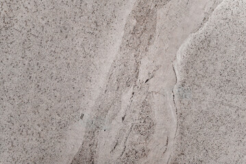 The stone is a mix of grey and white, with a white line running through it. The line is not very prominent, but it is noticeable. The stone is likely a type of marble or granite
