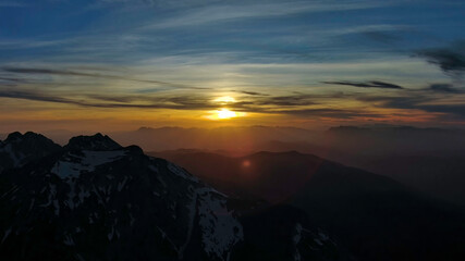 Rocky snow mountains at sunset aerial