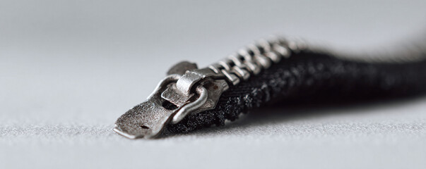 A detailed closeup image of a metallic zipper. Represents precision, functionality, and attention to detail. Ideal for fashion, design, or repair related projects.