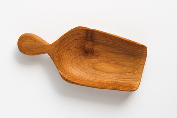 Hand-carved wooden measuring scoop isolated on a white background.