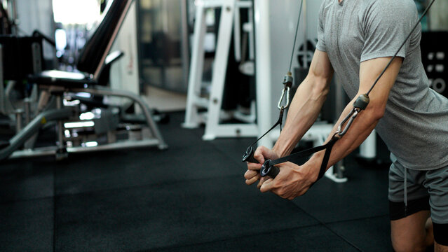young man in the gym. a man is doing chest exercises using a cable machine in the gym. athlete exercise with cable crossover machine. cable crossover chest