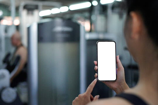 mockup hand holding a smartphone with transparent background with a gym blurred in the back