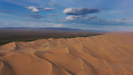 Aerial view of sand dunes in desert at sunset