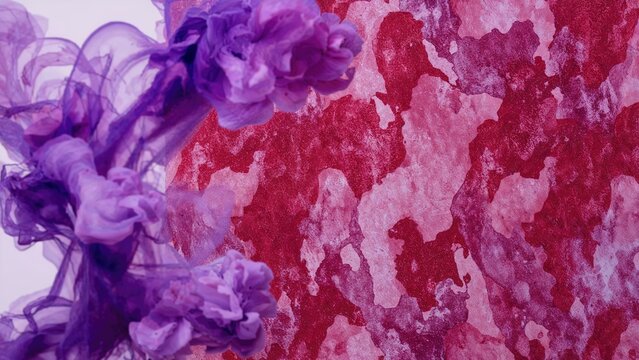 Purple ink or paint swirling with clouds over a red textured background.