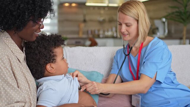 Female pediatrician examining a mixed-race boy on a sofa