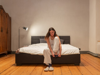 Woman siting on the bed and preparing to go to bed