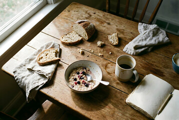 Rustic Breakfast with Oatmeal, Berries, Sourdough Bread, and Coffee at Sunrise.