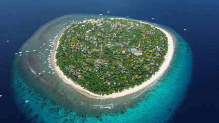 Tropical island surrounded by turquoise waters and coral reefs