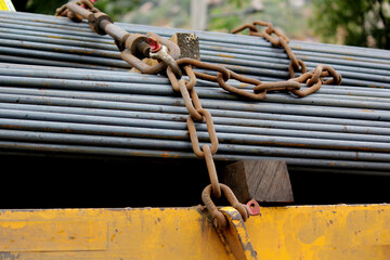 Heavy Steel Rods Secured with Chain for Construction Transport Safety
