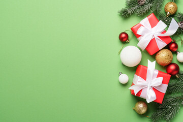 Christmas gift box and holiday decorations at green background.