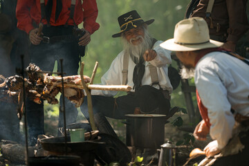 Group of cowboys preparing food at a campfire, roasting meat together in a warm