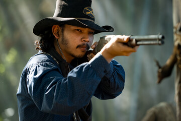 A cowboy aiming rifle in a forest camp, with sunlight streaming through the smoke