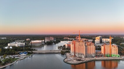 Ongoing construction of tall building by the lake at sunset in USA 