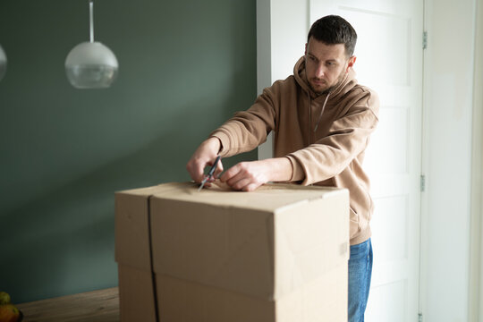 A man unpacks a recently delivered parcel, demonstrating reliable shipping services and well-organized logistics. Illustrates order processing and logistical excellence in today's connected 