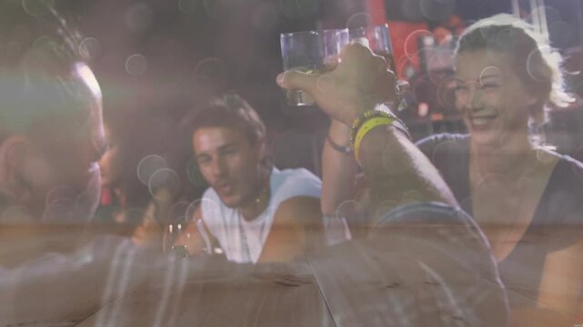 Front man lifting glass and starting toast at bar, group celebrating, sipping with flare bokeh - Powered by Adobe