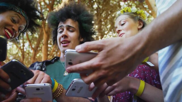 Five friends under trees tapping phones and sharing social post, creating yellow confetti overlay